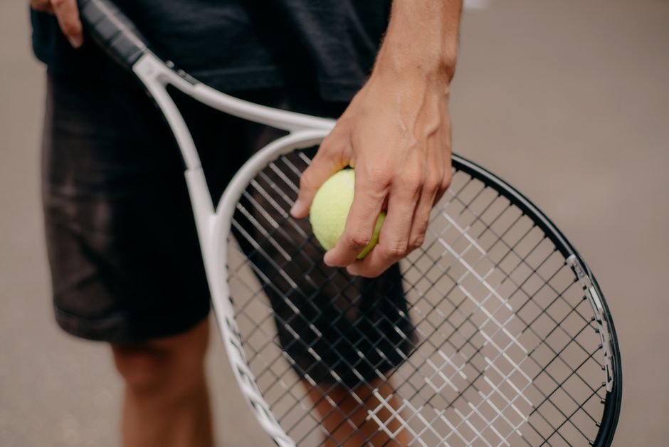 Hand gripping a paddle representing how to hold a pickleball paddle