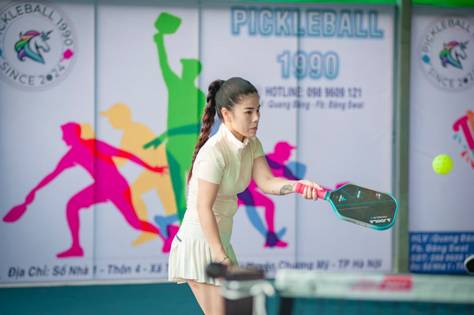 Pickleball player mid-rally with paddle on an indoor court
